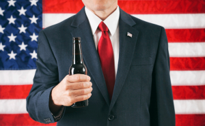 Preppy Man with a beer in front of the Flag