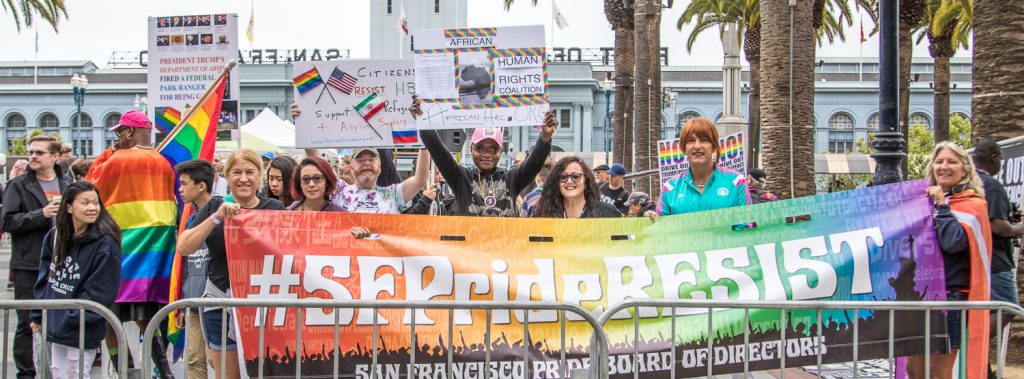 Geoffrey, Junior, Melanie and others behind the SF Pride RESIST banner